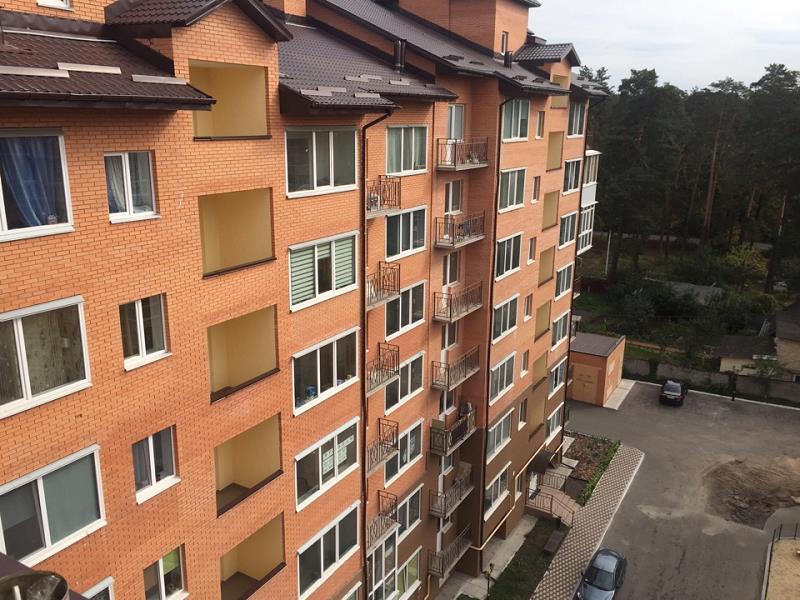Цегляний фасад житлового комплексу Ворзель Парк поруч із деревами